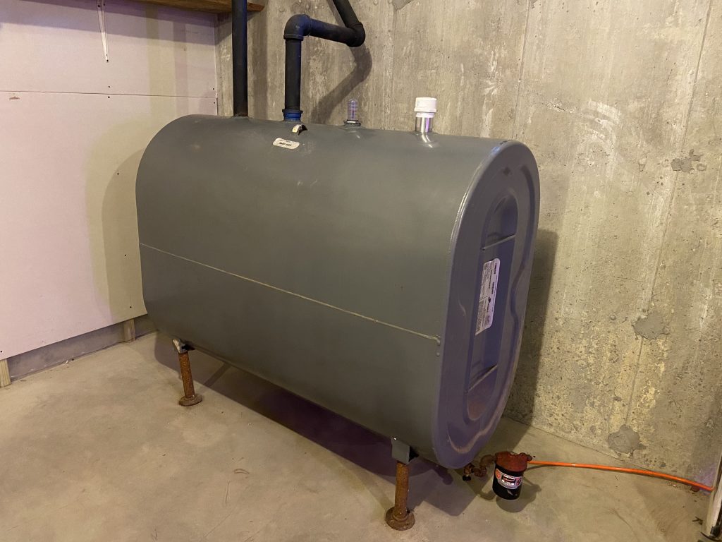 275 gallon steel oil tank in a basement. The tank is out of sight for the homeowner, and the homeowner is able to order heating oil from any dealer in their area.